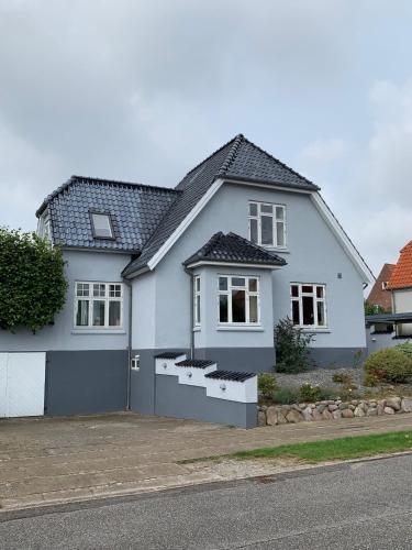 a white house with a gray roof at Central by lejlighed in Nykøbing Falster