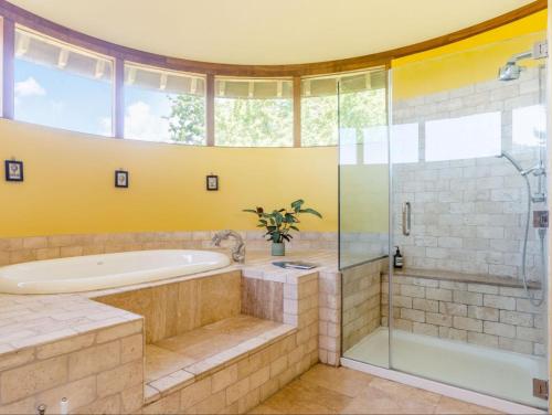 La salle de bains est pourvue d'une baignoire et d'une douche en verre. dans l'établissement The Oast House - Hartley Wine Estate, à Alton