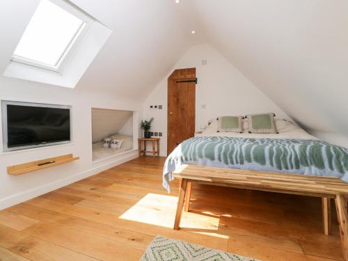 a bedroom with a bed and a flat screen tv at The Rookery in Burford