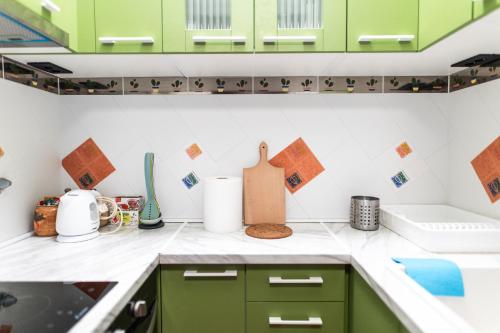 a kitchen with green cabinets and white counter tops at Ugi house - City Center in Belgrade