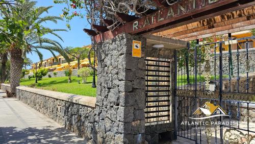 una pared de piedra con una puerta en un parque en Atlantic Paradise, en Costa del Silencio