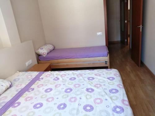 a small room with a bed with a purple blanket at Pis a Bellpuig in Bellpuig