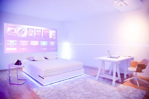 a bedroom with a bed and a desk with a laptop at Cosy Apartment at Prenzlauer Berg with Terrace and HeadphoneCinema in Berlin