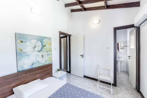 a bedroom with a bed and a painting on the wall at Villa Joelena in Lachi