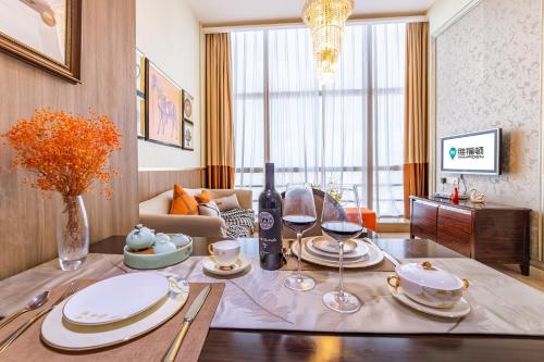 廣州的住宿－廣州正佳金殿維福頓公寓（正佳廣場店），客厅配有带盘子和酒杯的桌子