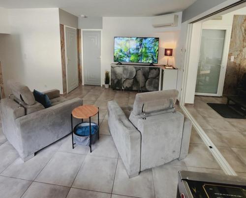 un salon avec des canapés et une télévision à écran plat dans l'établissement Etoiles de Provence PRESTIGE, à La Ciotat