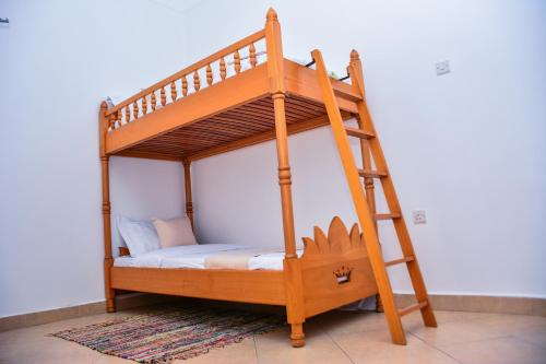 ein Etagenbett aus Holz mit einer Leiter in einem Zimmer in der Unterkunft Savani Apartments, Kabale. in Kabale