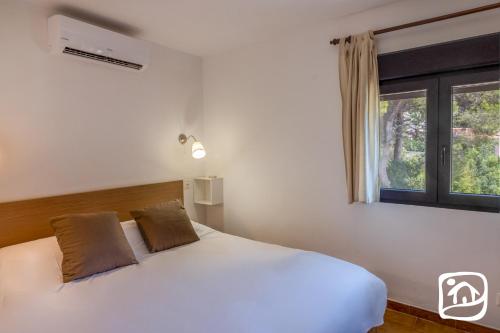 モライラにあるVilla Los Pasitos by Abahana Villasの窓付きの客室の白いベッド1台
