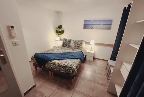 - une petite chambre avec un lit et deux lampes dans l'établissement Etoiles de Provence PRESTIGE, à La Ciotat