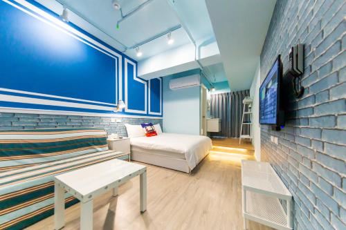 um quarto com uma cama, um sofá e uma televisão em 高雄靉嗨文旅 em Kaohsiung