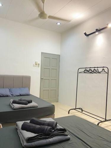 a room with two beds and a mirror in it at Homestay 2 @Taman Teluk Intan in Teluk Intan