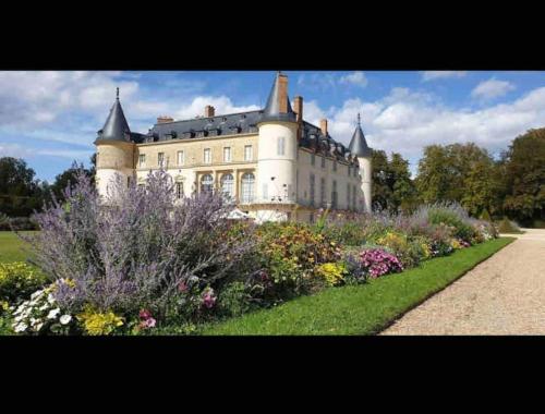 un grand château avec un jardin en face dans l'établissement Bel appartement proche gare et centre-ville, à Rambouillet