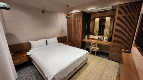 a bedroom with a white bed and a desk at Barry Hotel in İzmir