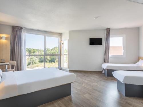 een hotelkamer met 2 bedden en een raam bij B&B HOTEL Aix en Provence Venelles in Venelles