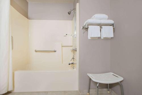 a white bathroom with a tub and a sink at Super 8 by Wyndham Pella in Pella