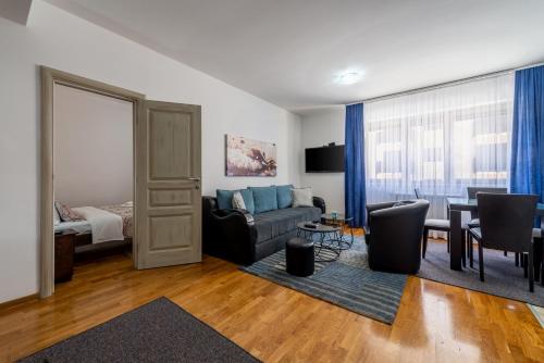 ein Wohnzimmer mit einem Sofa und einem Tisch in der Unterkunft Apartment Maksi-Centar in Zlatibor