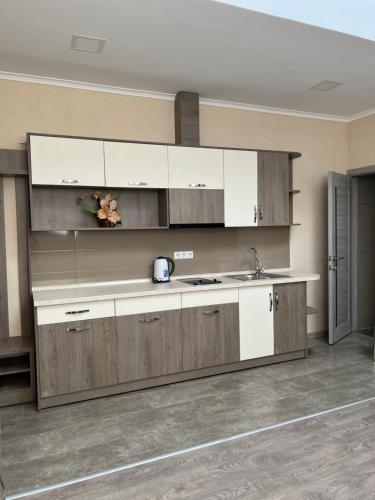 a kitchen with white and brown cabinets and a sink at Elite Hotel in Bălţi