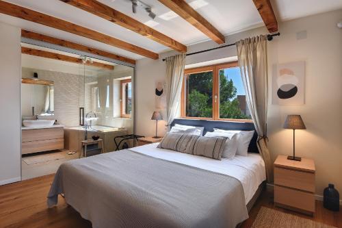 um quarto com uma grande cama branca e uma casa de banho em CASA MARE ISTRIA, villa with private pool, near the beach, with the sea view! em Peroj