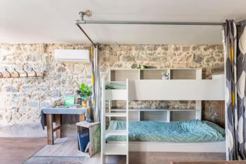 - une chambre avec des lits superposés et un bureau dans l'établissement Le Bonheur En Beaujolais - pour 26 Personnes - BY PRIMO C0NCIERGERIE, à Saint-Didier-sur-Beaujeu