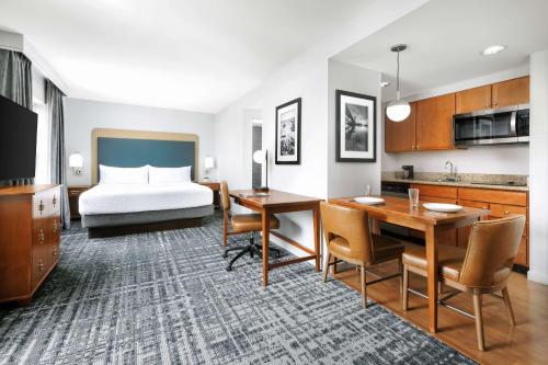 ein Hotelzimmer mit einem Bett, einem Schreibtisch und einer Küche in der Unterkunft Homewood Suites by Hilton Portsmouth in Portsmouth