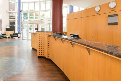 an office with wooden cabinets and a long counter at NH Dresden Neustadt in Dresden