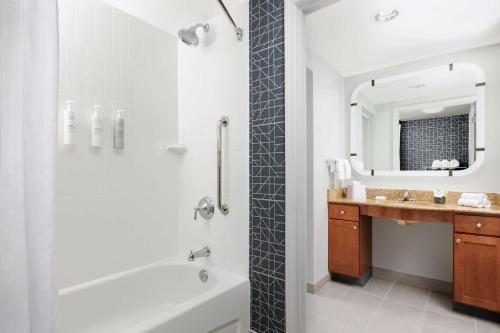 a bathroom with a tub shower and a sink at Homewood Suites by Hilton Portsmouth in Portsmouth