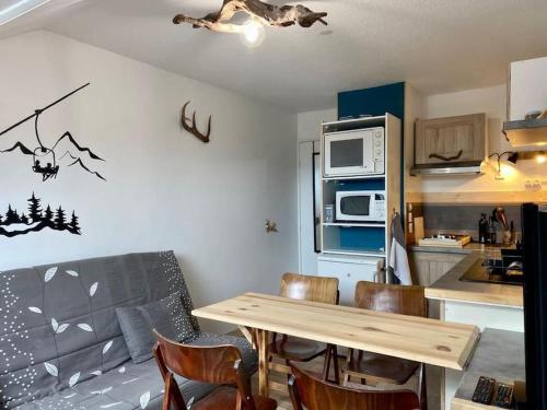 une cuisine avec une table et des chaises dans une pièce dans l'établissement Studio cabine 4 personnes pied des pistes samedi à samedi, à Bolquère-Pyrénées 2000