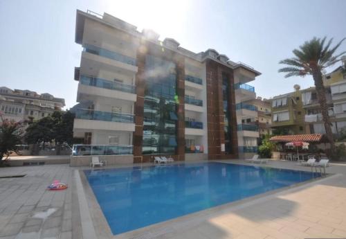 un gran edificio de apartamentos con una gran piscina en Sun Homes: A Travellers Paradise, en Alanya