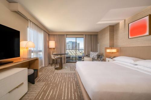 um quarto de hotel com uma cama grande e uma televisão em Hilton San Diego Gaslamp Quarter em San Diego