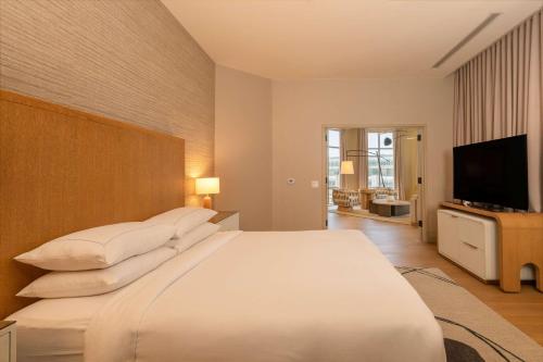 a bedroom with a large white bed and a flat screen tv at Hilton San Diego Gaslamp Quarter in San Diego