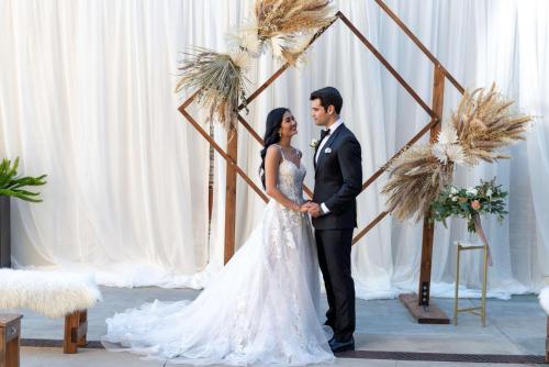 a bride and groom standing in front of a wedding altar at Hilton San Diego Gaslamp Quarter in San Diego