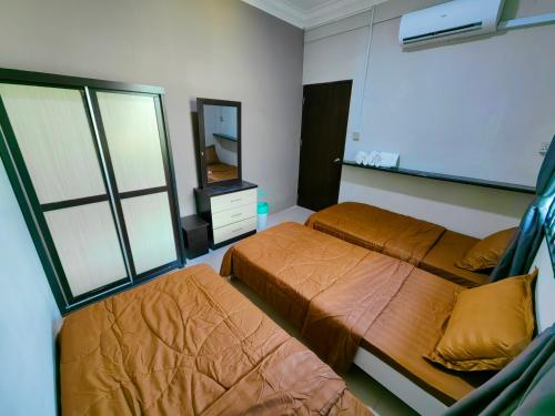 a bedroom with two beds and a mirror at AaronL Homestay in Kota Kinabalu