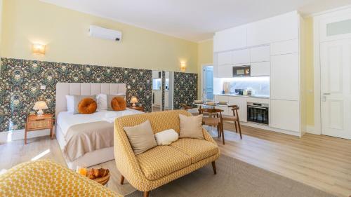a bedroom with a bed and a chair and a kitchen at Urban House Marquês by LovelyStay in Porto