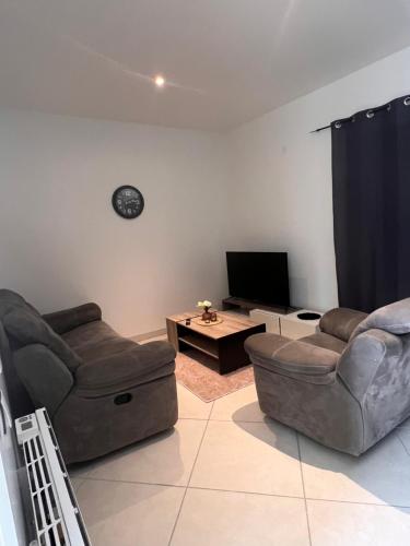 a living room with two couches and a tv at Résidence Mk Evasion in Jonzac