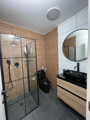 a bathroom with a black toilet and a mirror at דירת אירוח מפנקת בעיר אשקלון - 5 דקות נסיעה מהים in Ashqelon