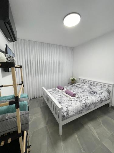 a bedroom with a white bed with purple pillows on it at דירת אירוח מפנקת בעיר אשקלון - 5 דקות נסיעה מהים in Ashkelon