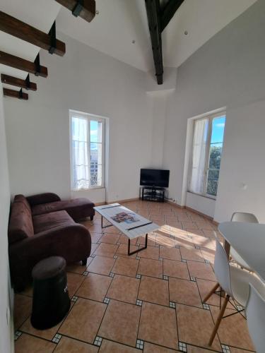 un salon avec un canapé et une table dans l'établissement Appartement T3 centre ville Nîmes Climatisé, à Nîmes