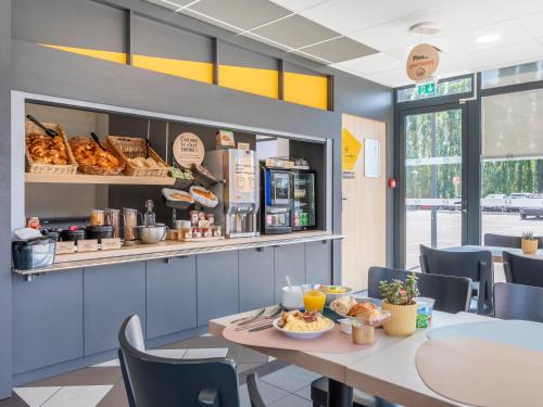 a cafeteria with a table with food on it at B&B HOTEL Aix en Provence Venelles in Venelles