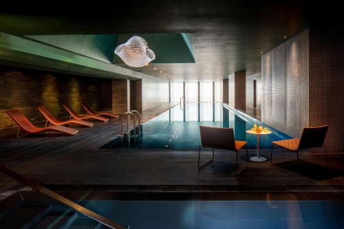 uma piscina com cadeiras e uma mesa num edifício em Anantara The Marker Dublin- A Leading Hotel of the World em Dublin