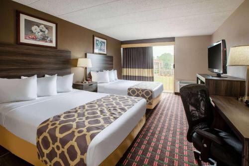 a hotel room with two beds and a television at Baymont by Wyndham Northwood in Northwood