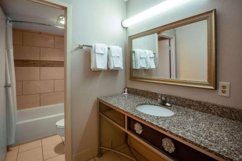 a bathroom with a sink and a mirror and a toilet at Baymont by Wyndham Northwood in Northwood