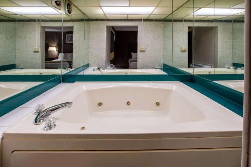 a large bath tub in a bathroom with mirrors at Baymont by Wyndham Northwood in Northwood