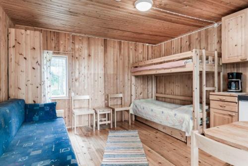 a bedroom with a bunk bed and a desk and a kitchen at Holiday Village Himmerki in Posio