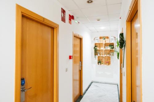 a hallway with a wooden door and a floor at Hotel Isla Menor in Dos Hermanas
