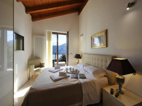 sypialnia z łóżkiem ze stołem i lampką w obiekcie Villa Lumbini w mieście Plesio