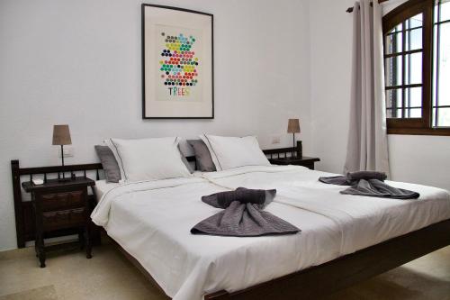 una camera da letto con un grande letto bianco con asciugamani sopra di Panoramic Seaview Escape a Puerto de Santiago