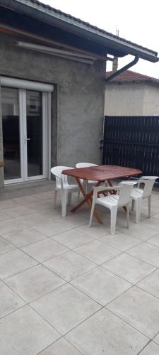 - une table de pique-nique et des chaises sur la terrasse dans l'établissement Chez Emile, à Brézins