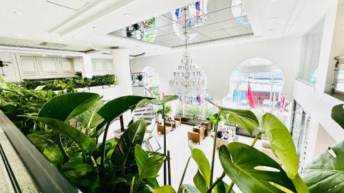 a room filled with lots of plants and a chandelier at Harmony Phnom Penh Hotel in Phnom Penh