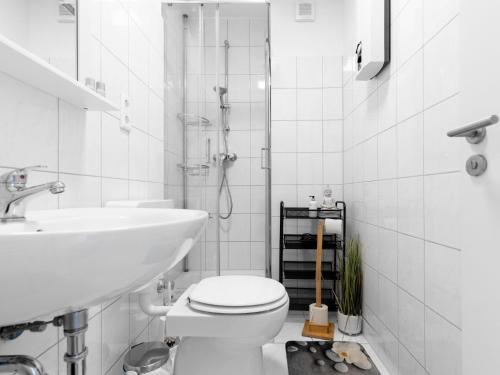 a white bathroom with a toilet and a sink at # VAZ Apartments E01 Küche, TV, Netflix, ca 15 Min Messe u HBf in Essen