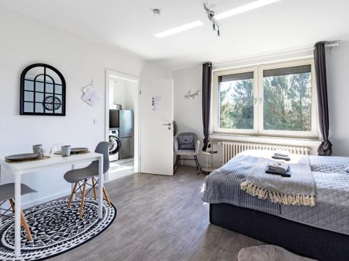 um quarto com uma cama, uma secretária e janelas em # VAZ Apartments E01 Küche, TV, Netflix, ca 15 Min Messe u HBf em Essen